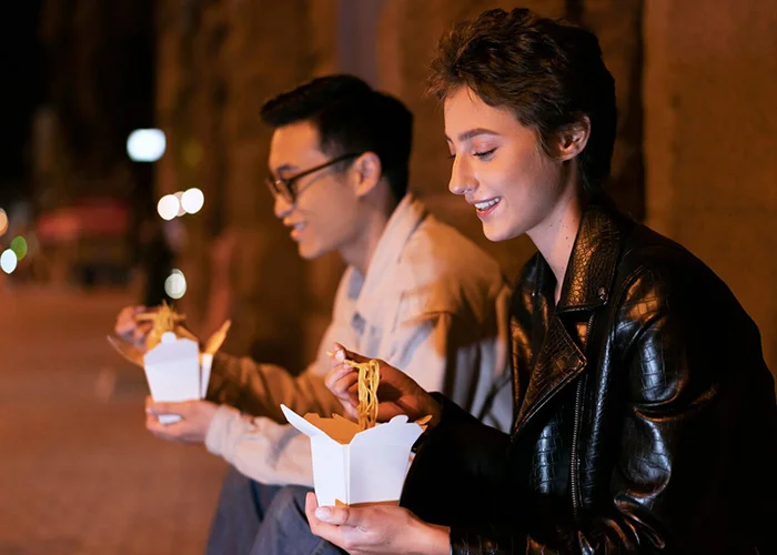 un par de personas comiendo comida